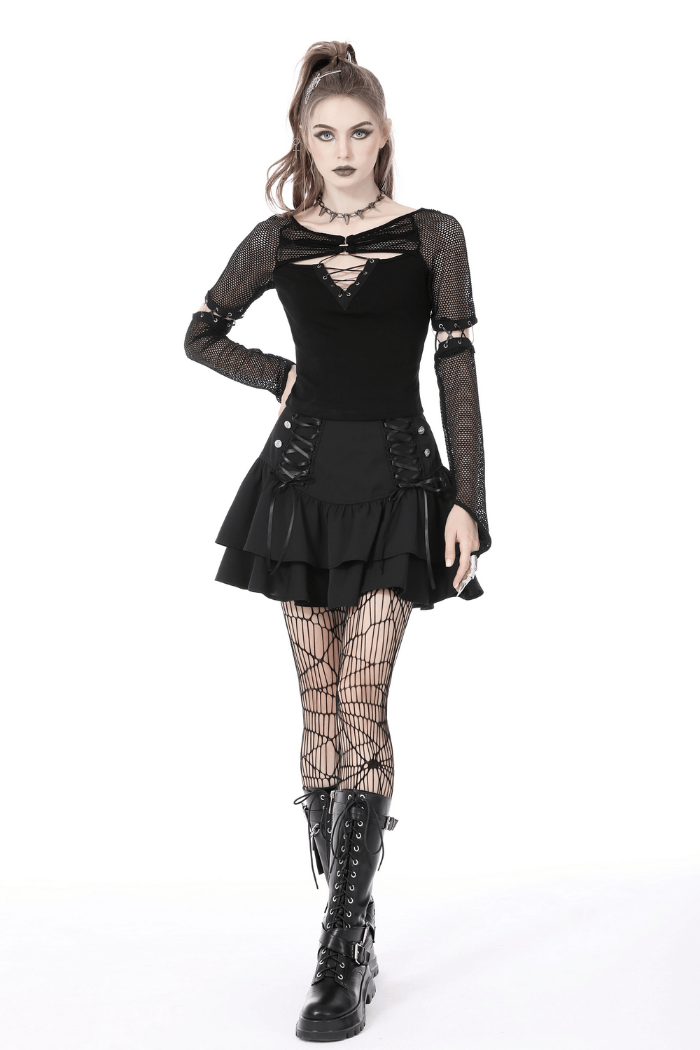 Stylish female in black mesh goth top with lace-up sleeves, paired with a flared skirt and fishnet tights.