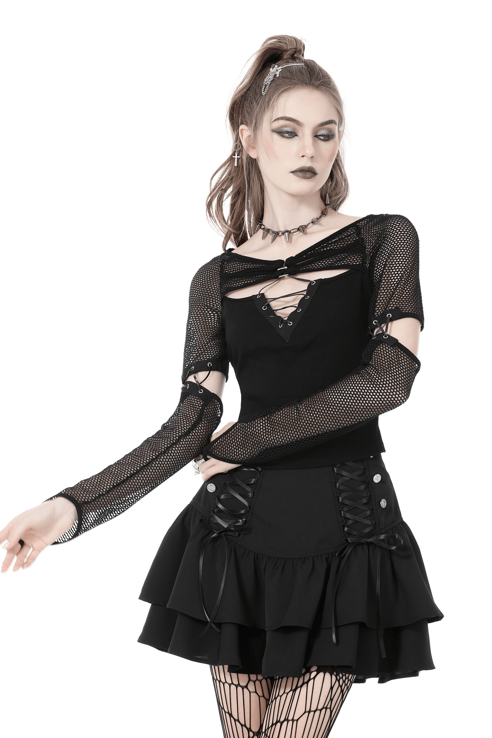 Stylish female model in black mesh goth top with lace-up sleeves, paired with a ruffled black skirt for a dark, trendy look.