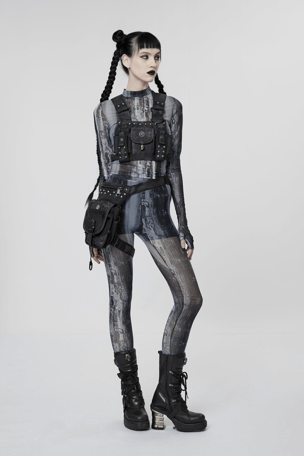 Stylish female model in punk outfit showcasing black skull studded strap bag and edgy combat boots.