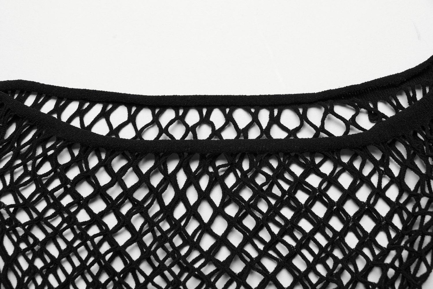 Close-up of a stylish black fishnet off-shoulder top showcasing a bold, edgy design and intricate mesh pattern.