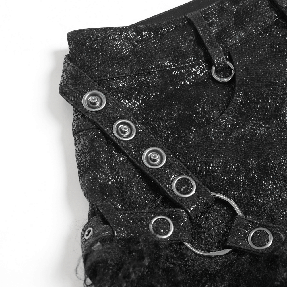 Close-up of stylish gothic black faux leather shorts featuring button details and metal rings.