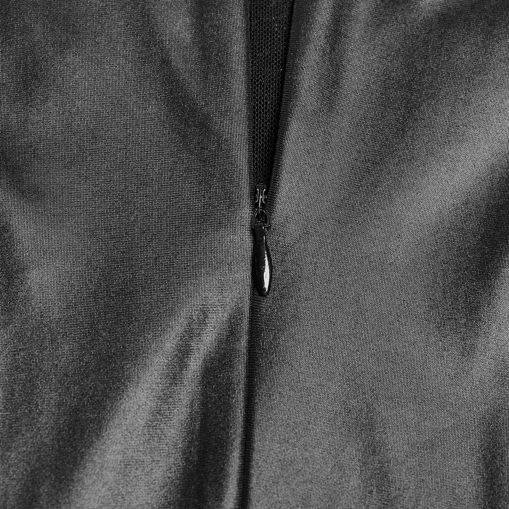 Close-up of sleek black zipper on gothic mini dress, showcasing quality and design details.