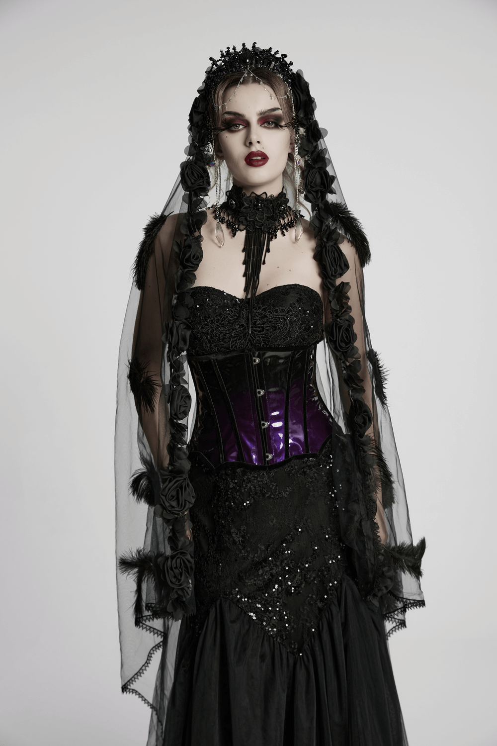 Gothic model in stylish glossy underbust corset with purple gradient, adorned with flowers and veil, perfect for alt fashion.