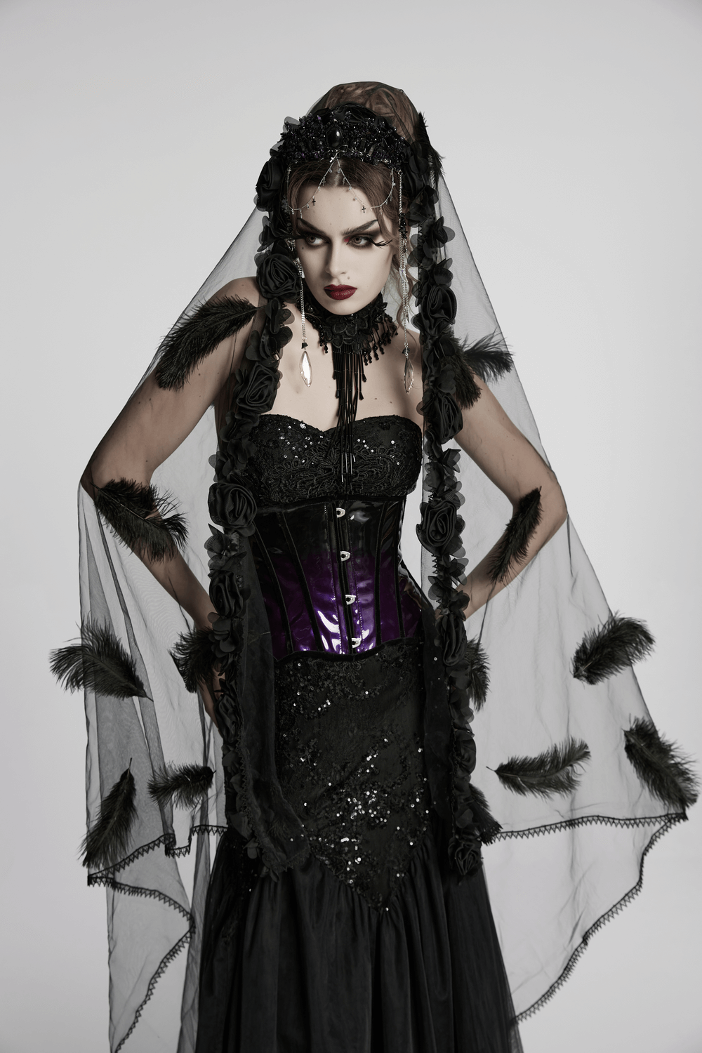 Model in stylish gothic outfit with patent leather corset and dramatic black veil.