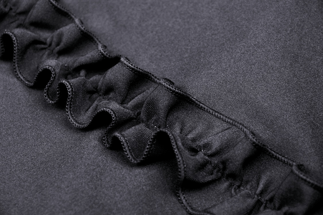 Close-up of black fabric with delicate ruffled detail, perfect for a Gothic dress design.
