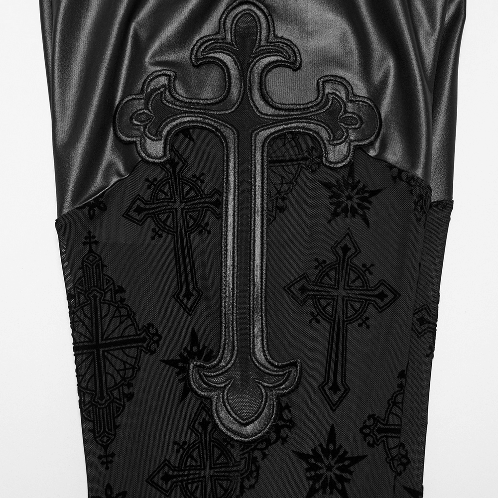 Close-up of gothic flared pants with cross embroidery and mesh panels, showcasing stylish black fabric details.