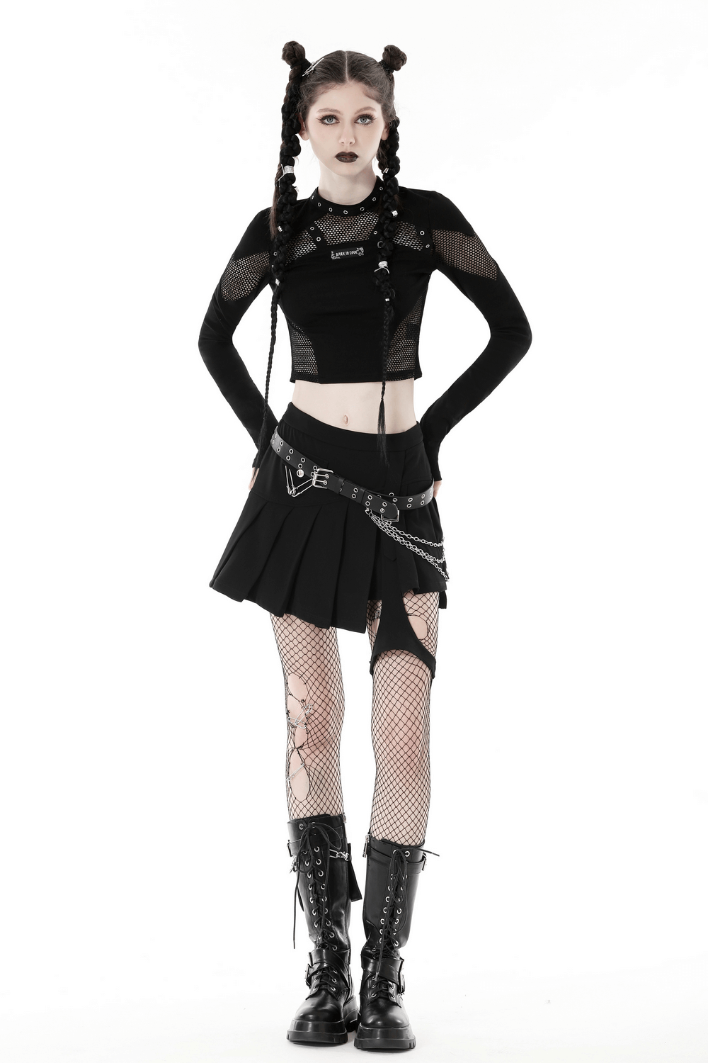 Gothic O-neck mesh crop top with cutouts, paired with a pleated skirt and lace-up boots for an edgy look.