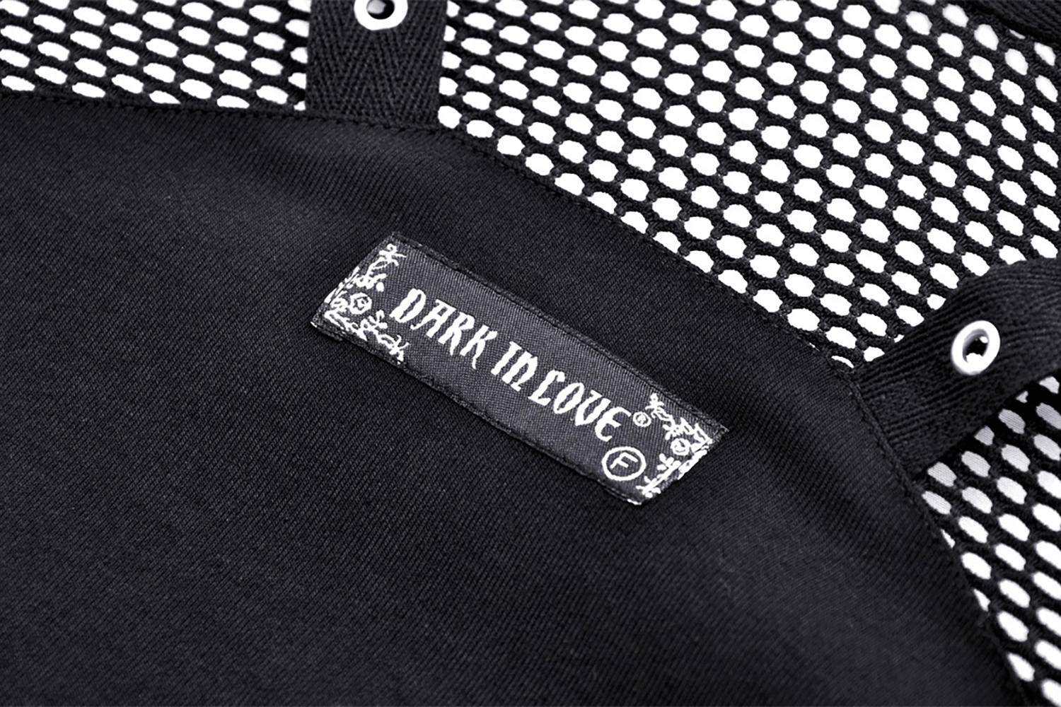 Close-up of the DARK IN LOVE tag on a stylish black mesh crop top, showcasing edgy fashion vibes.