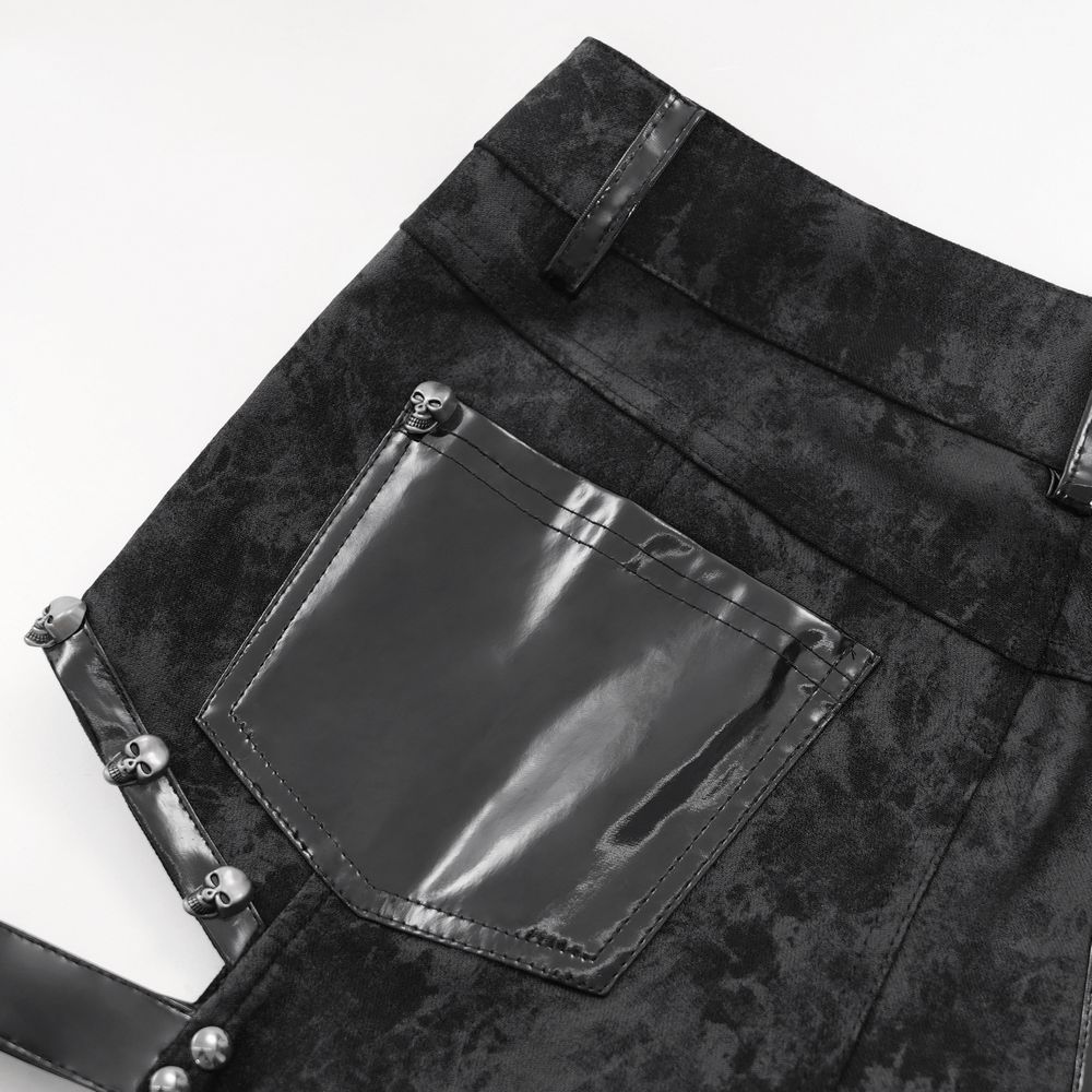 Close-up of stylish gothic pants featuring buckle details and a shiny patent leather pocket.