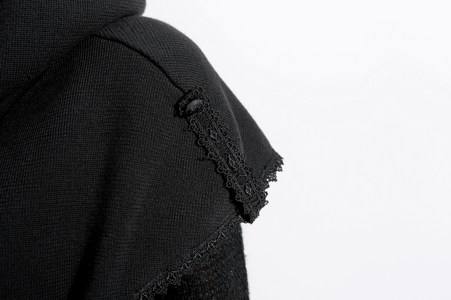Close-up of the stylish black knitted wool hood of a gothic wrap cape featuring decorative lace trim.