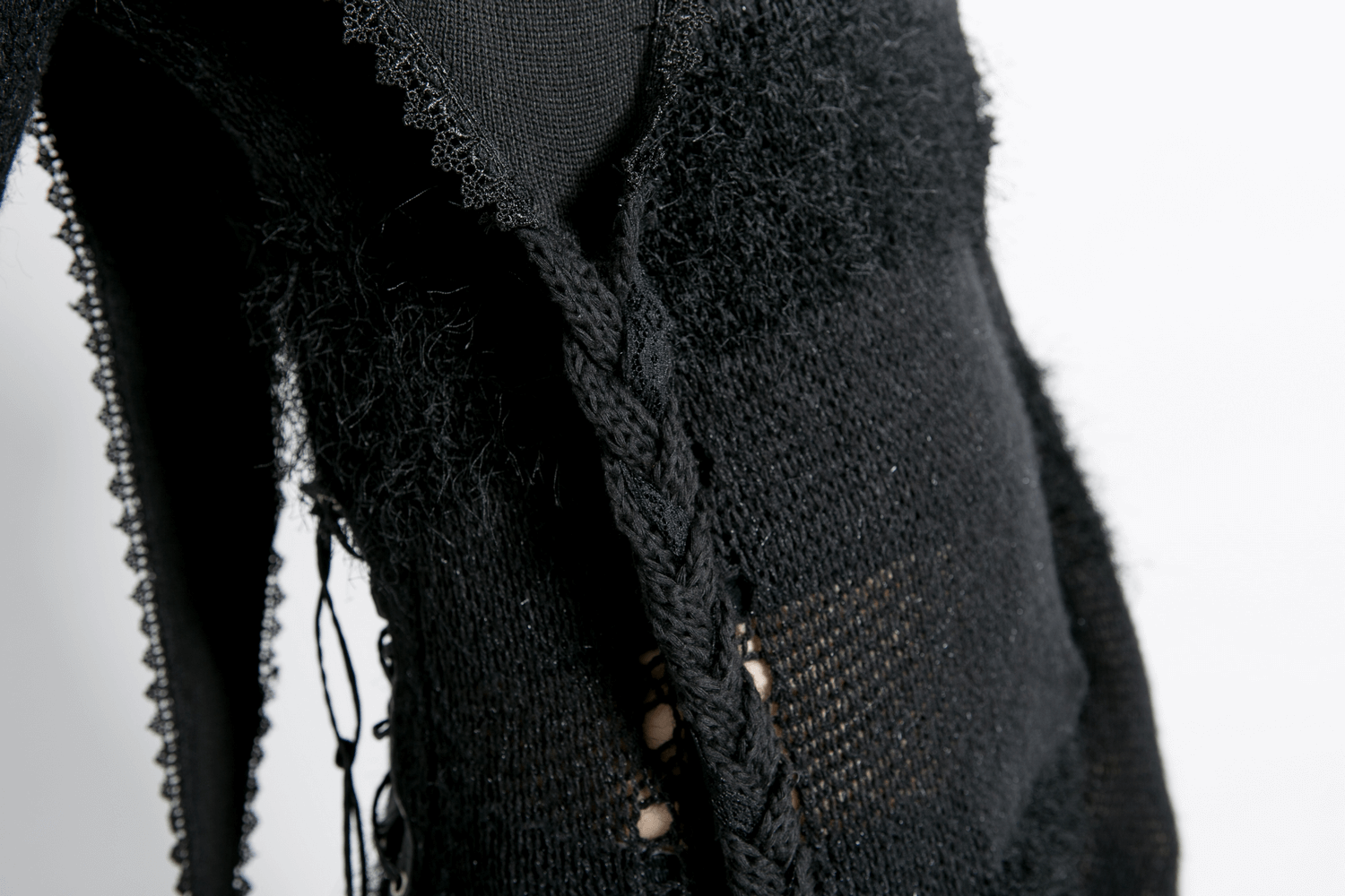 Close-up of a stylish black gothic knitted hooded wrap cape showcasing intricate textures and edgy detailing.