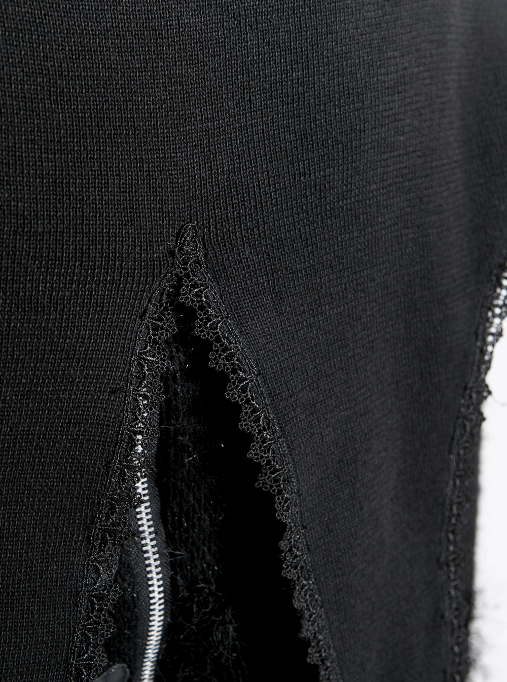 Close-up of the stylish black knitted wool cape showing intricate lace detailing and zipper accent.