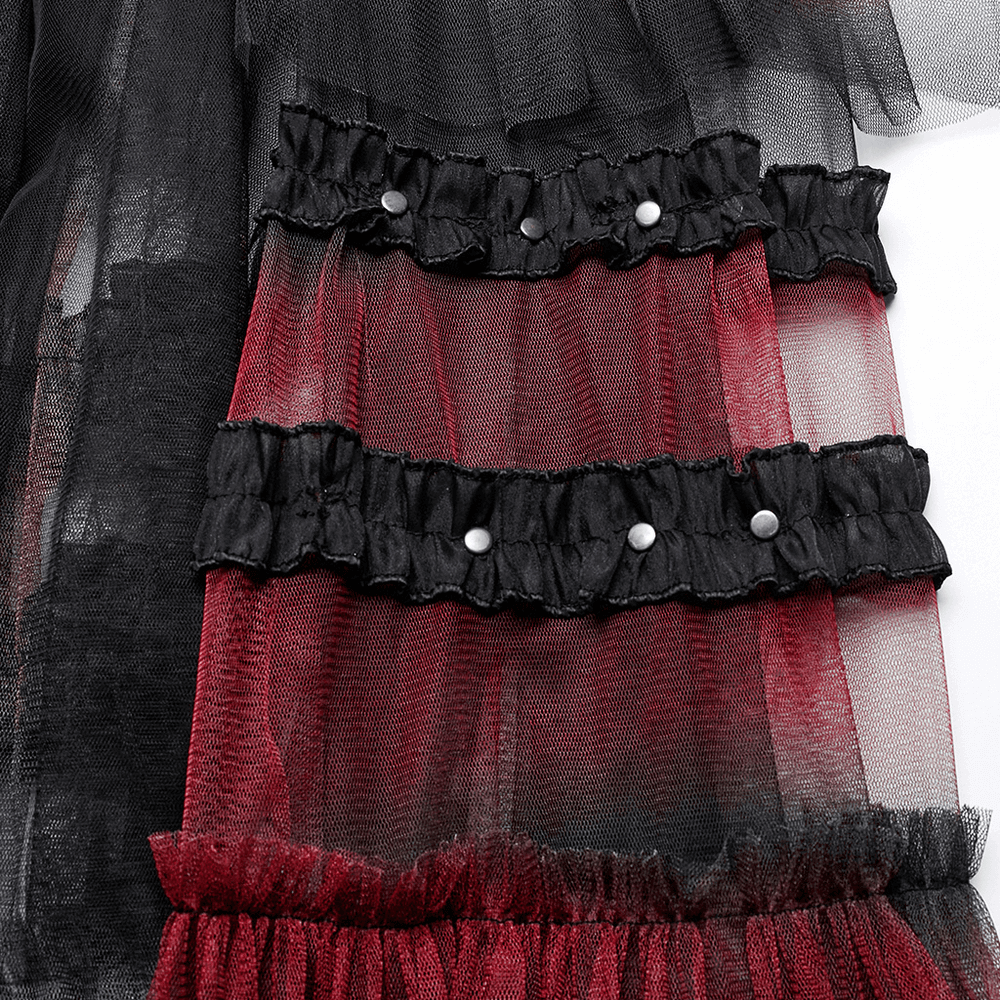 Close-up of stylish gradient mesh skirt with layered ruffles and decorative buttons, featuring bold black and red hues.