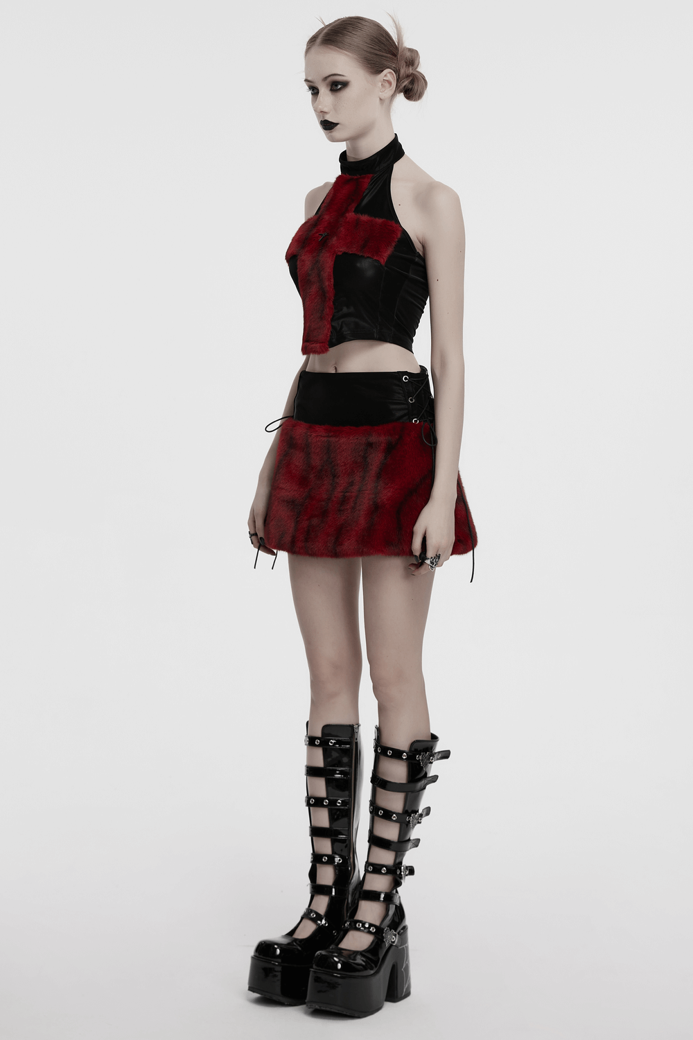 Stylish halter cross fur top with red tie-dye and edgy black skirt, paired with bold platform boots.