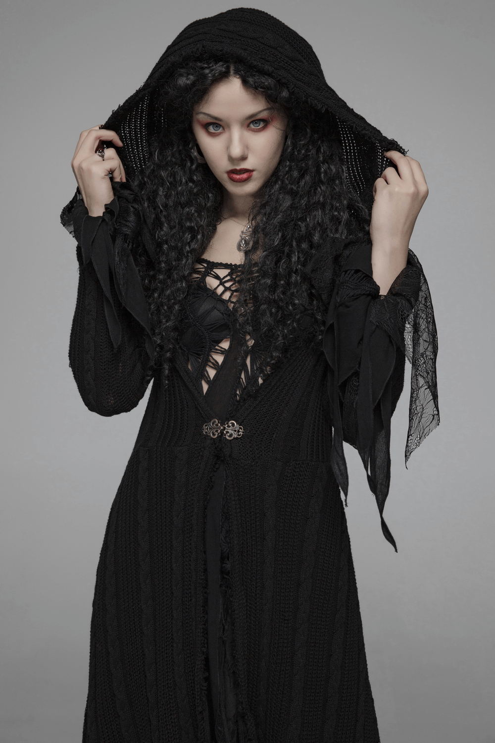 Stylish gothic woman in a hooded black cardigan with lace details, showcasing elegance and sophistication.