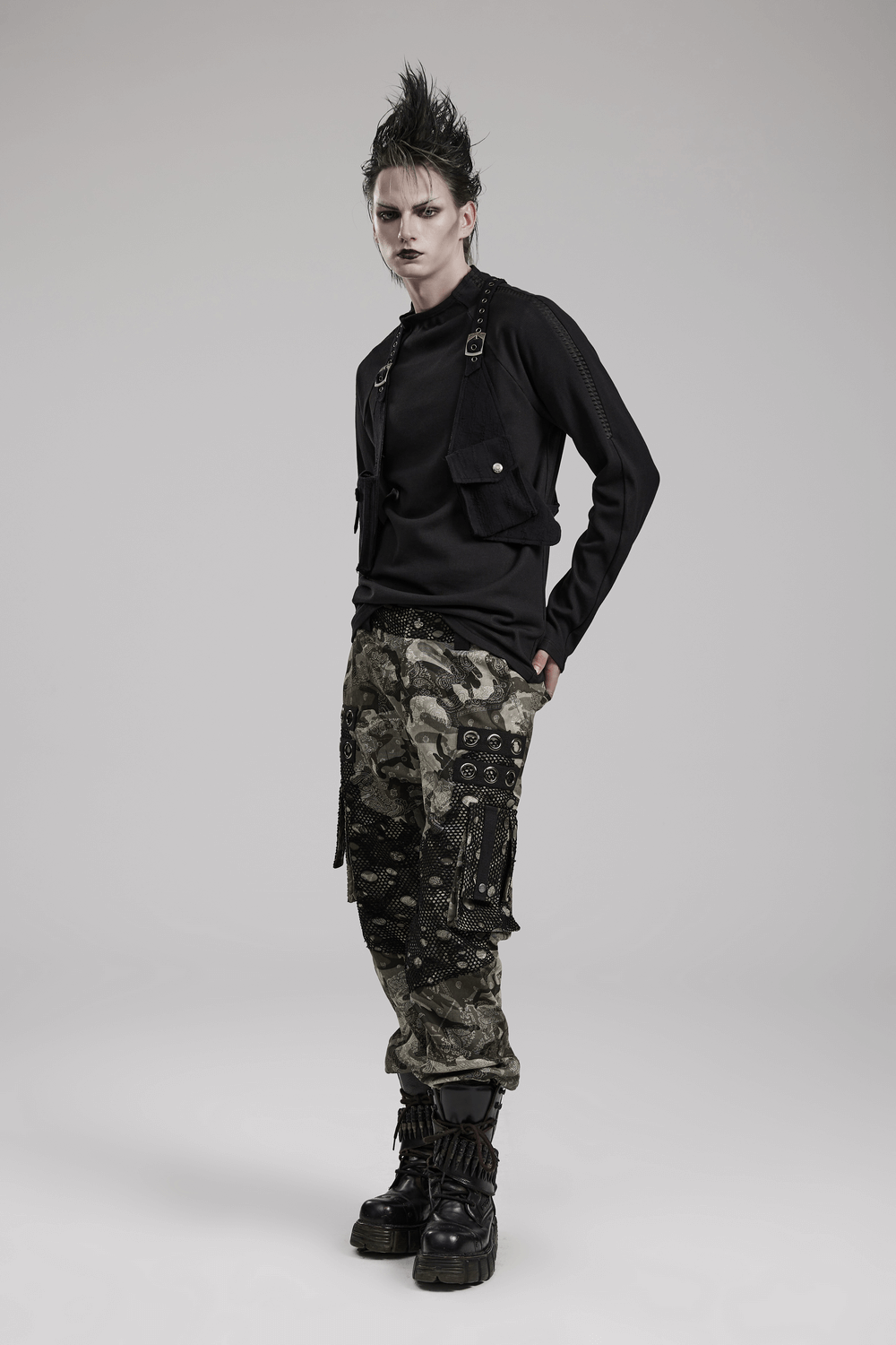 Edgy model showcasing a stylish knitted leather harness with pockets, paired with camo pants.