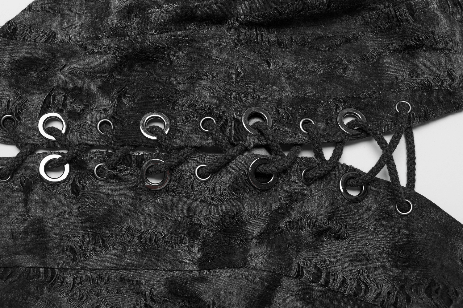 Close-up of edgy tattered black knit halter crop top with lace-up front and eyelets for adjustable fit.