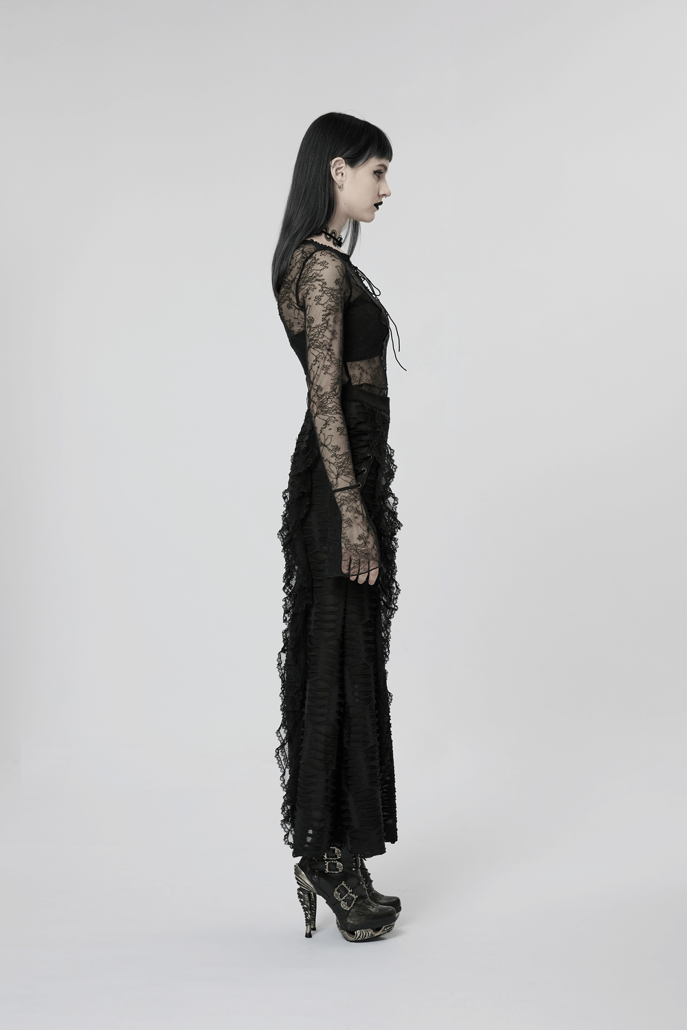 Side view of a model in a stylish layered gothic ruffle skirt with high slit and lace sleeves.