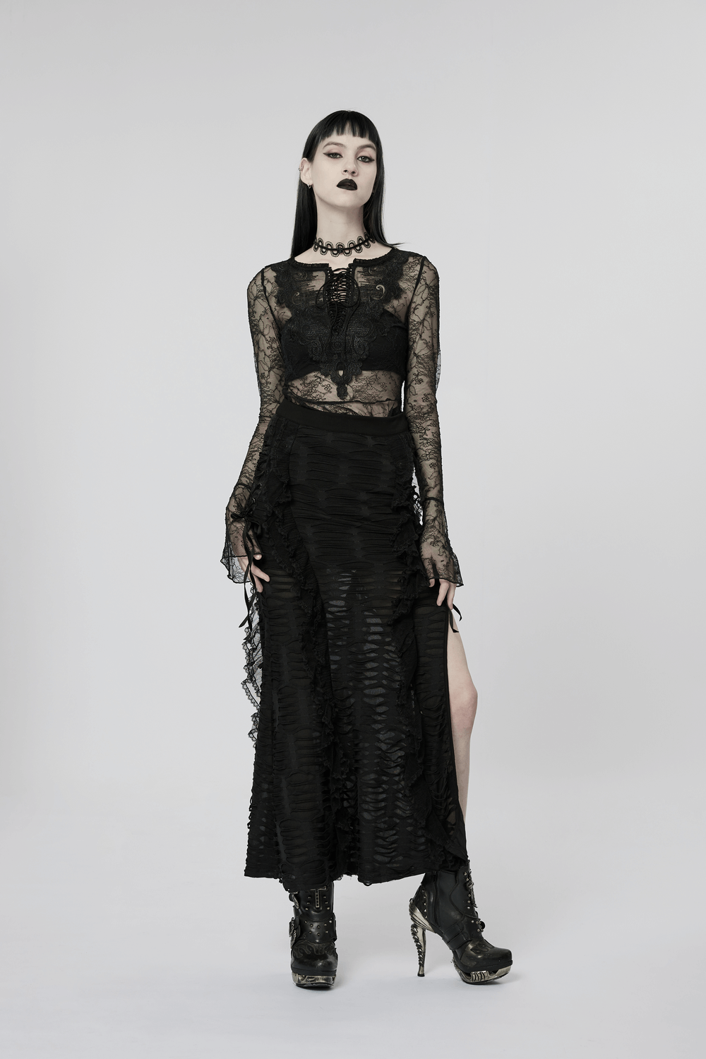 Model in a stylish gothic layered ruffle skirt with high slit and lace top, exuding edgy elegance and dark allure.