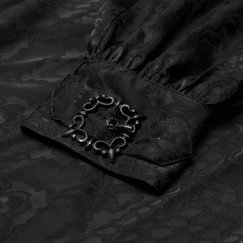 Close-up of the cuff of a black gothic jacquard shirt featuring a decorative metal carving buckle.
