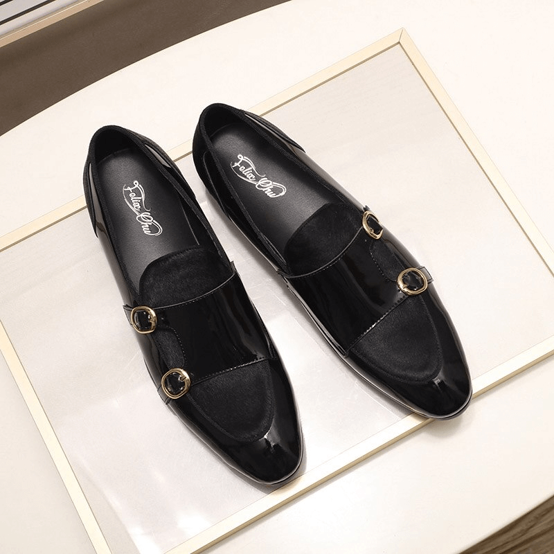 Stylish men's patent leather loafers with double buckles on a chic display, blending casual elegance and uniqueness.