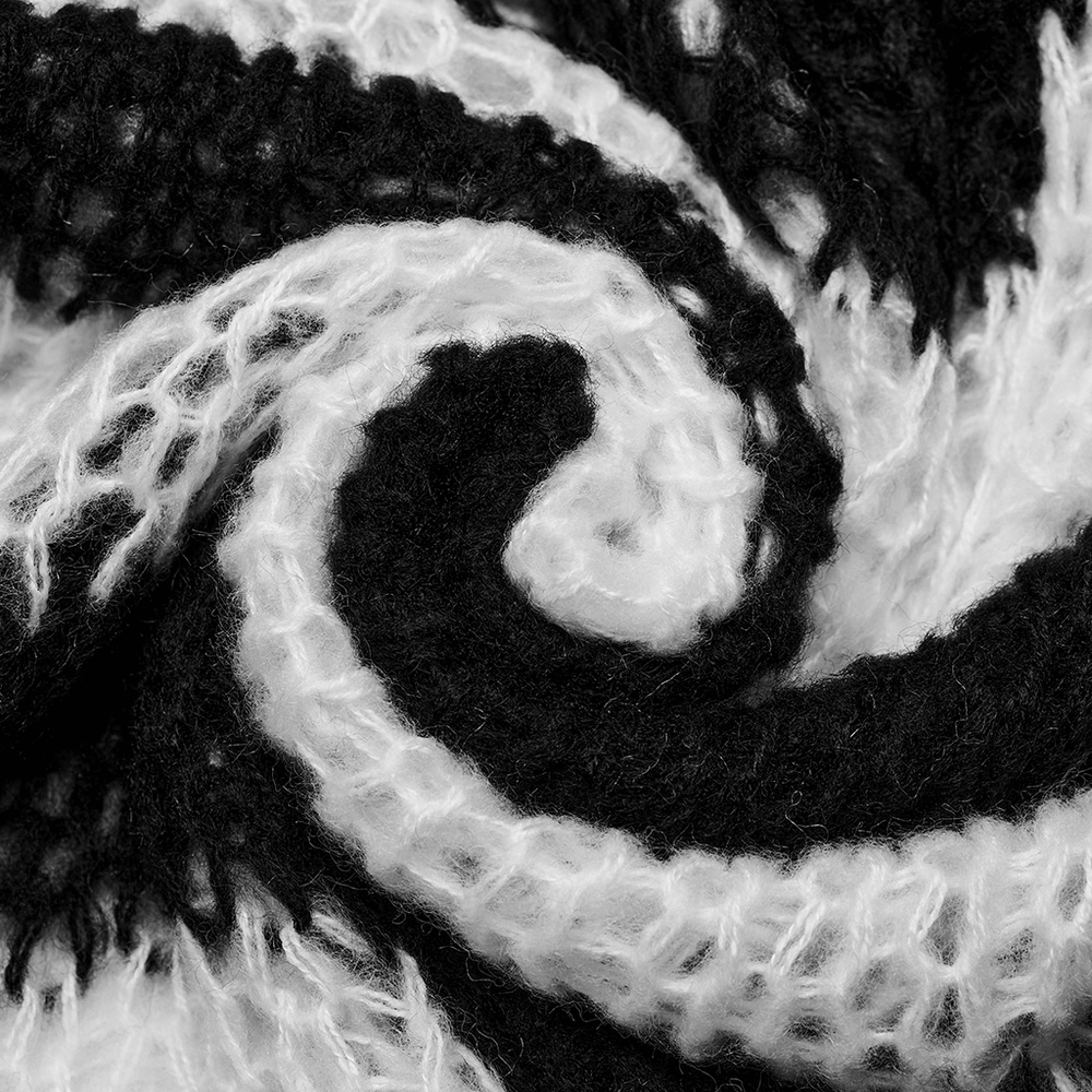 Close-up of mohair striped pullover showcasing soft black and white fabric with irregular holes, perfect for edgy styling.