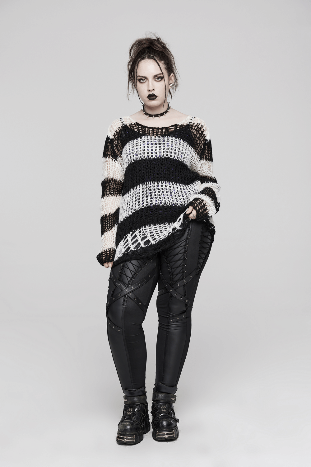 Rebellious model wears a stylish mohair striped pullover, showcasing edgy punk vibes with contrasting stripes and dramatic styling.