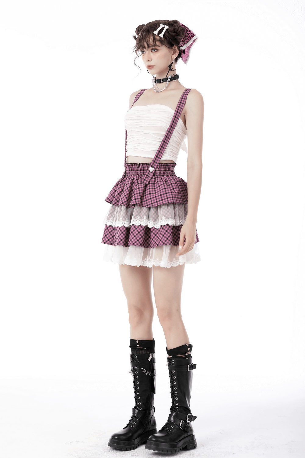 Model wearing a stylish pink kawaii pleated skirt with lace trim and ruffles, paired with chunky black boots.