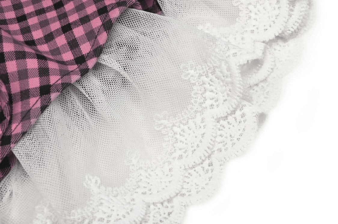 Stylish pink checkered skirt featuring delicate white lace trim with playful ruffles, perfect for classic and contemporary outfits.