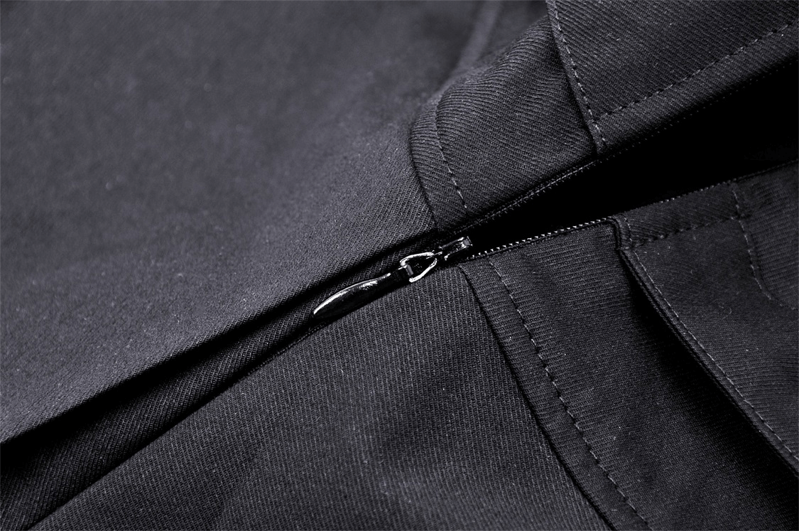 Close-up of the zipper detail on a stylish black pleated mini skirt. Perfect for a punk rock-inspired outfit.