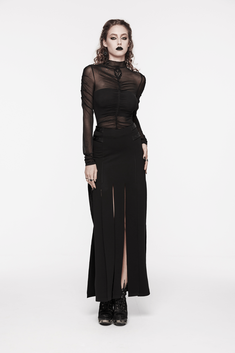 Stylish woman in a black long split skirt with fringe, showcasing edgy punk fashion.