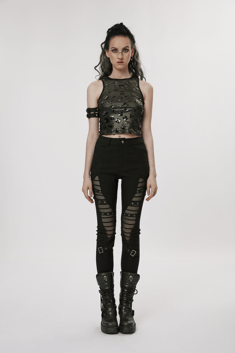 Stylish punk model in black mesh insert buckle skinny pants and metallic top, showcasing goth fashion aesthetic.