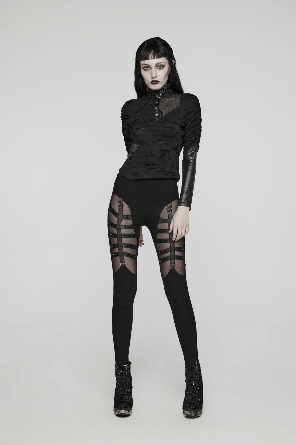 Edgy punk black mesh panel studded leggings, showcasing a stylish split design and wild strap decorations.