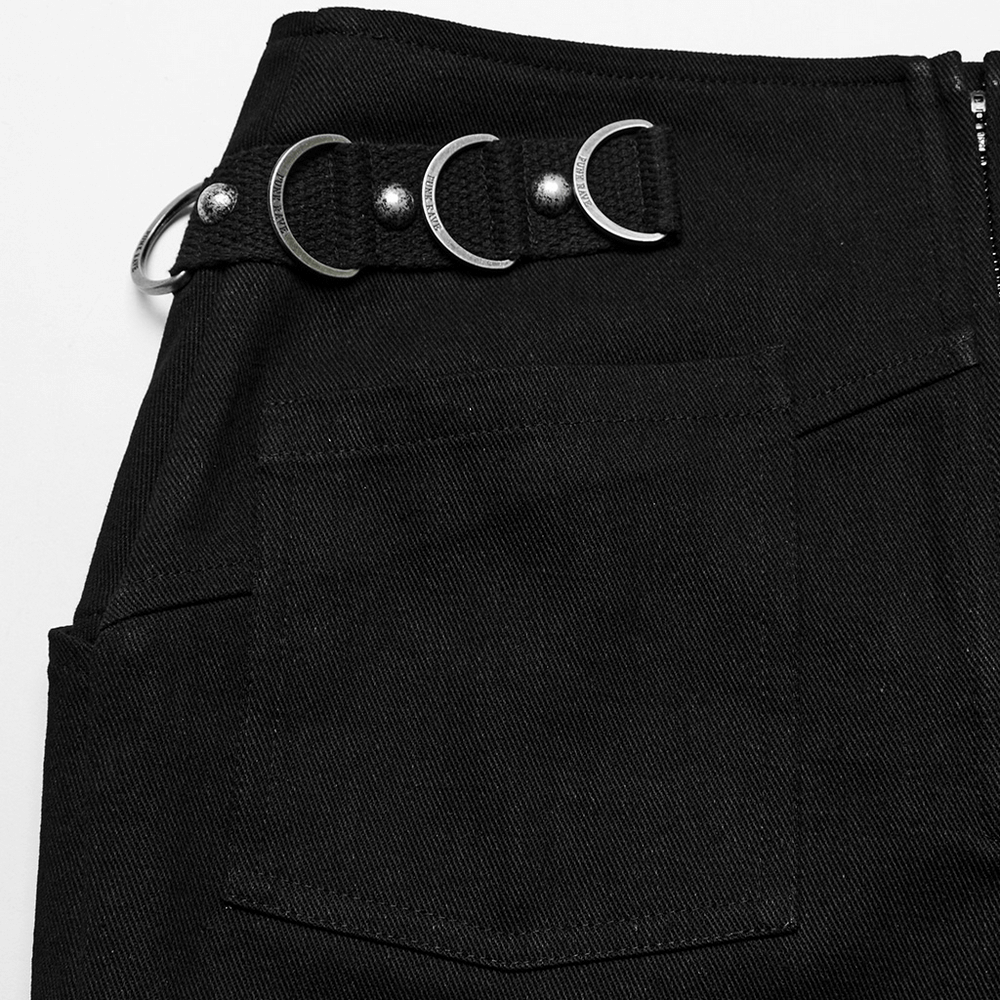 Close-up of stylish punk black mini skirt featuring metal rings and D-buckle on the waistband, showcasing edgy details.