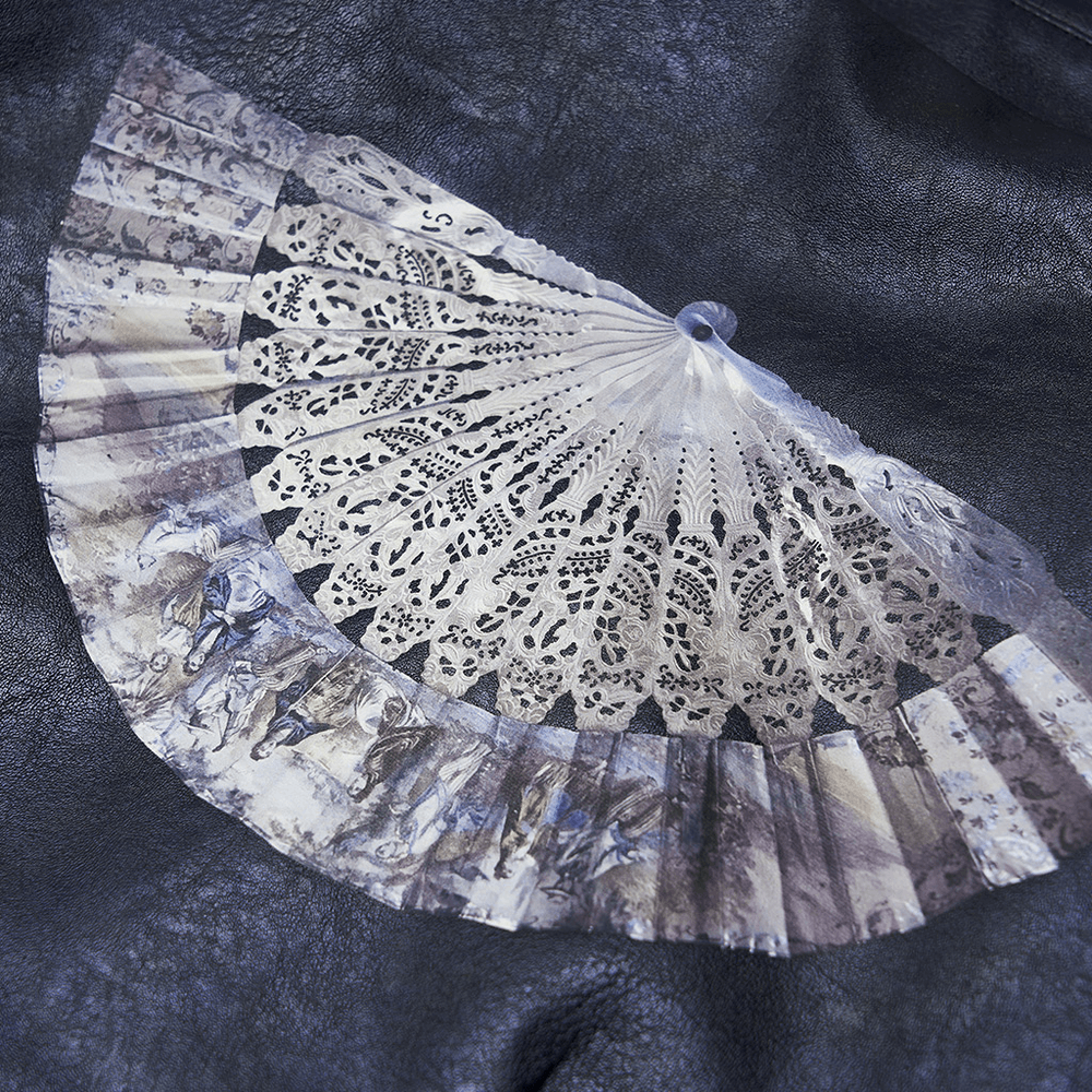 Close-up of a delicate lace fan design printed on a stylish punk cropped leather jacket.