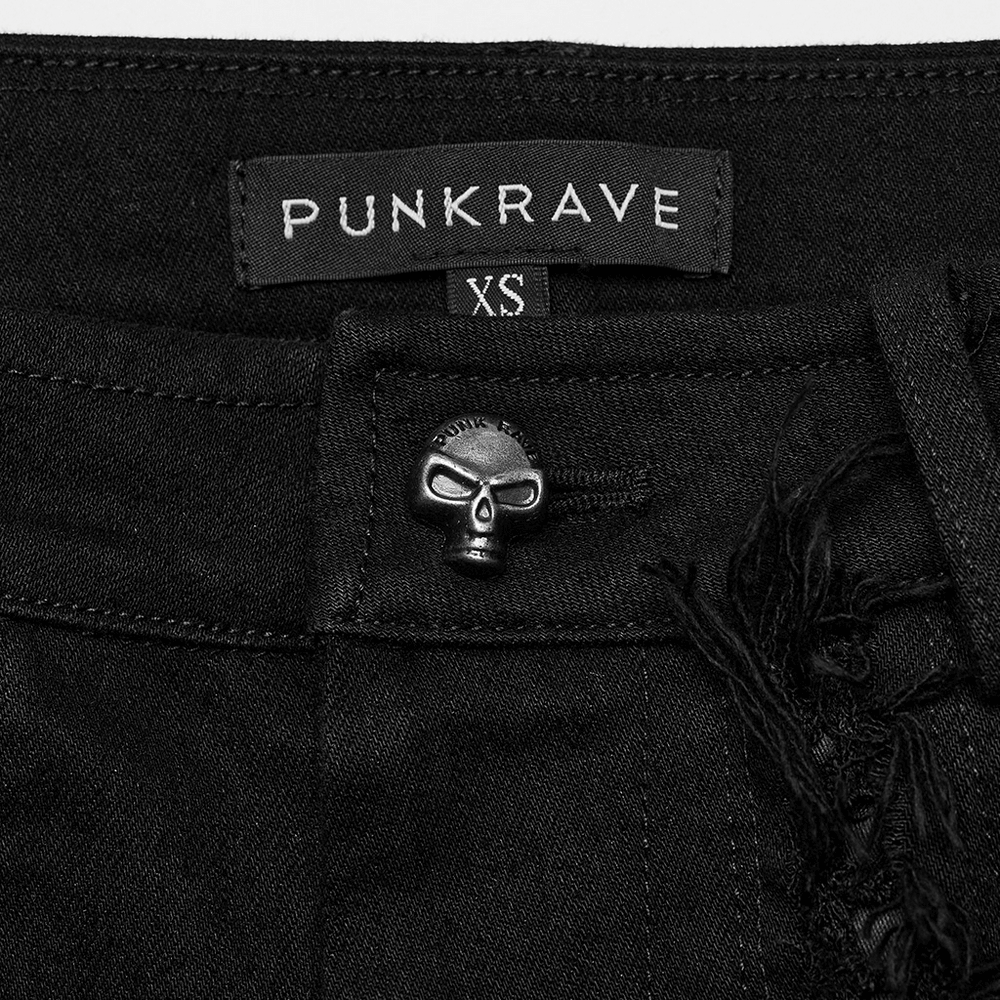 Close-up of PunkRave edgy denim flares with skull button and XS label, showcasing gothic style details.