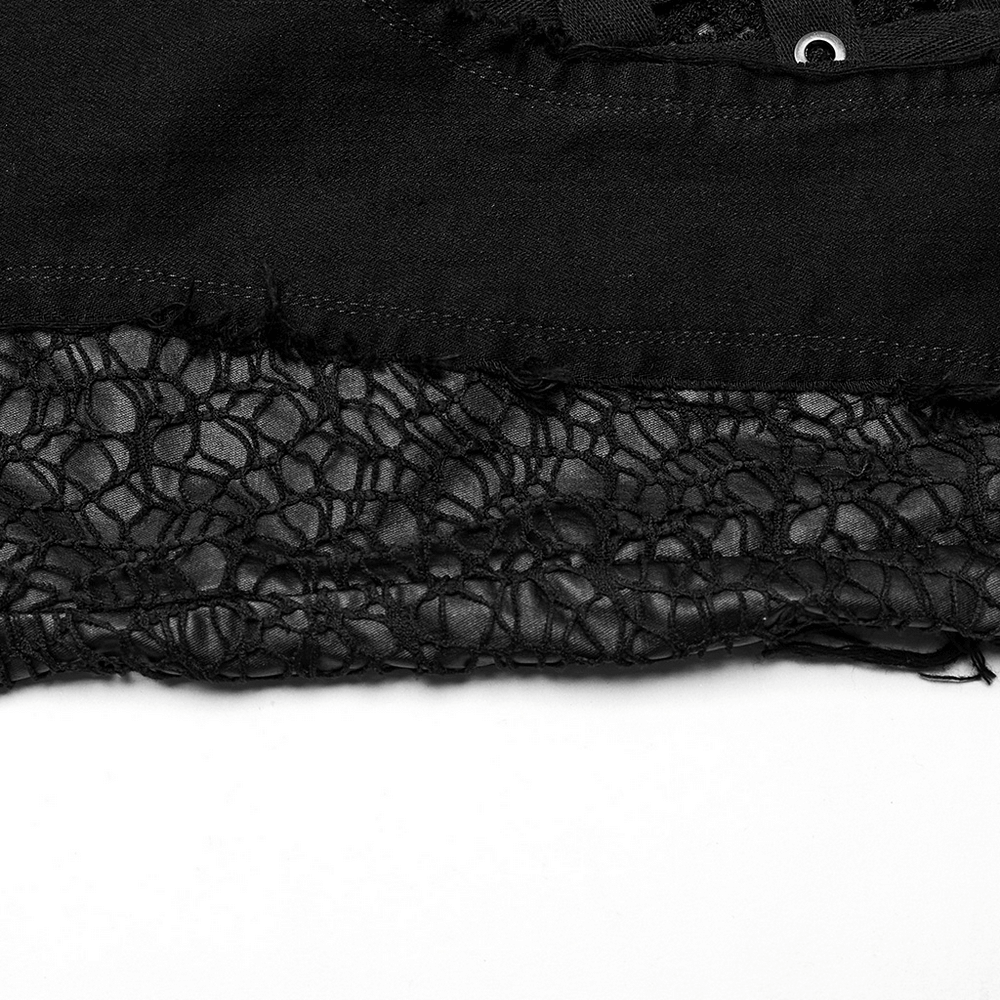 Close-up of black denim with edgy mesh insert, showcasing gothic style and punk fashion elements.