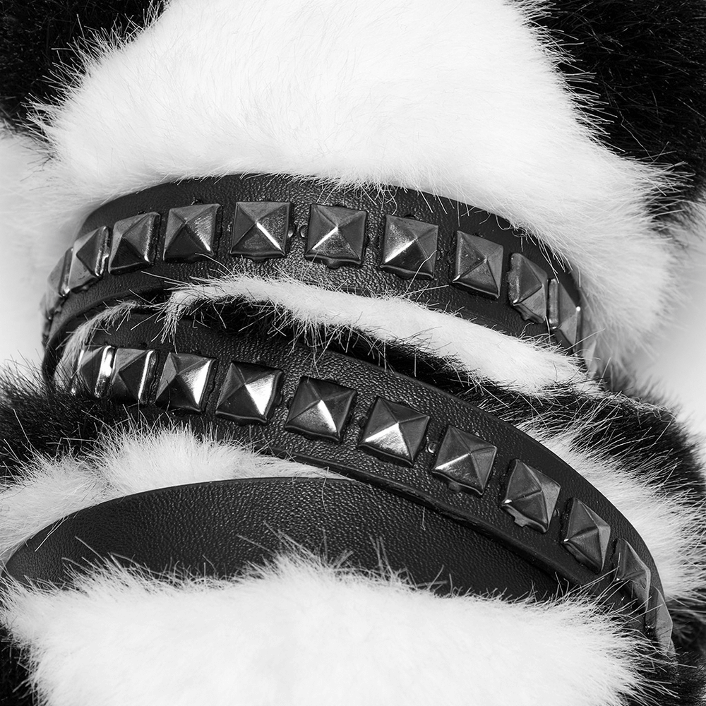 Close-up of studded black straps on a stylish punk panda faux fur keychain, highlighting edgy detail and texture.