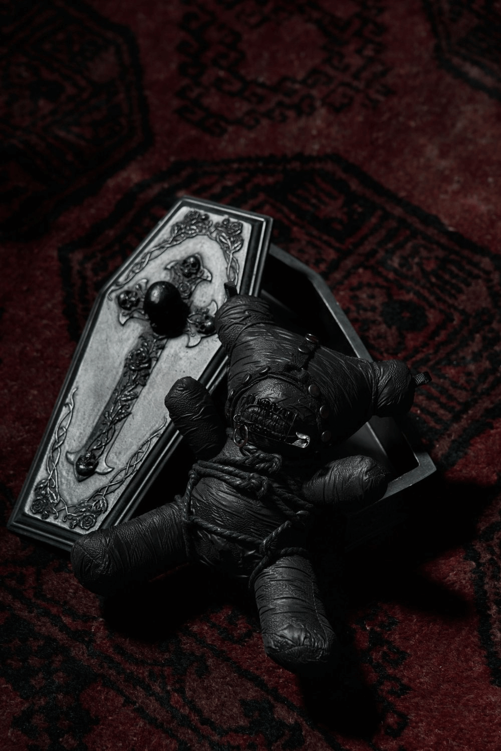 Gothic Taboo Bear plush in a coffin with a black textured design, showcasing edgy punk rave decor.