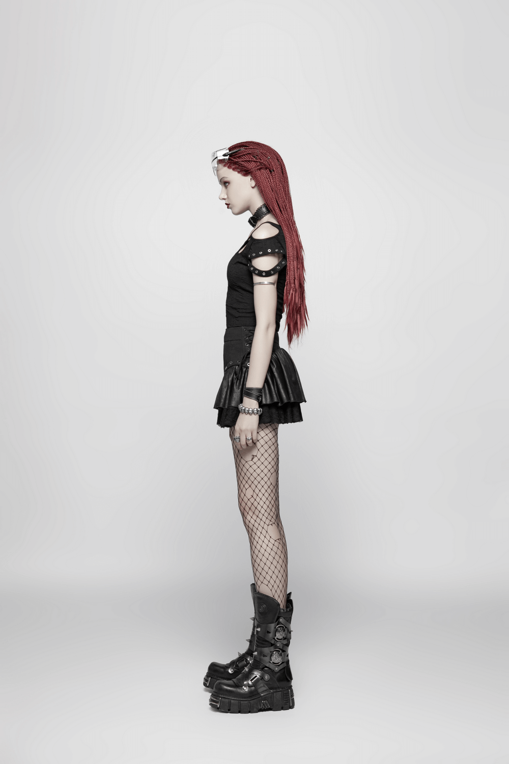 Side view of a model wearing a stylish black punk rave mini skirt with ruffles and lace, paired with edgy accessories.