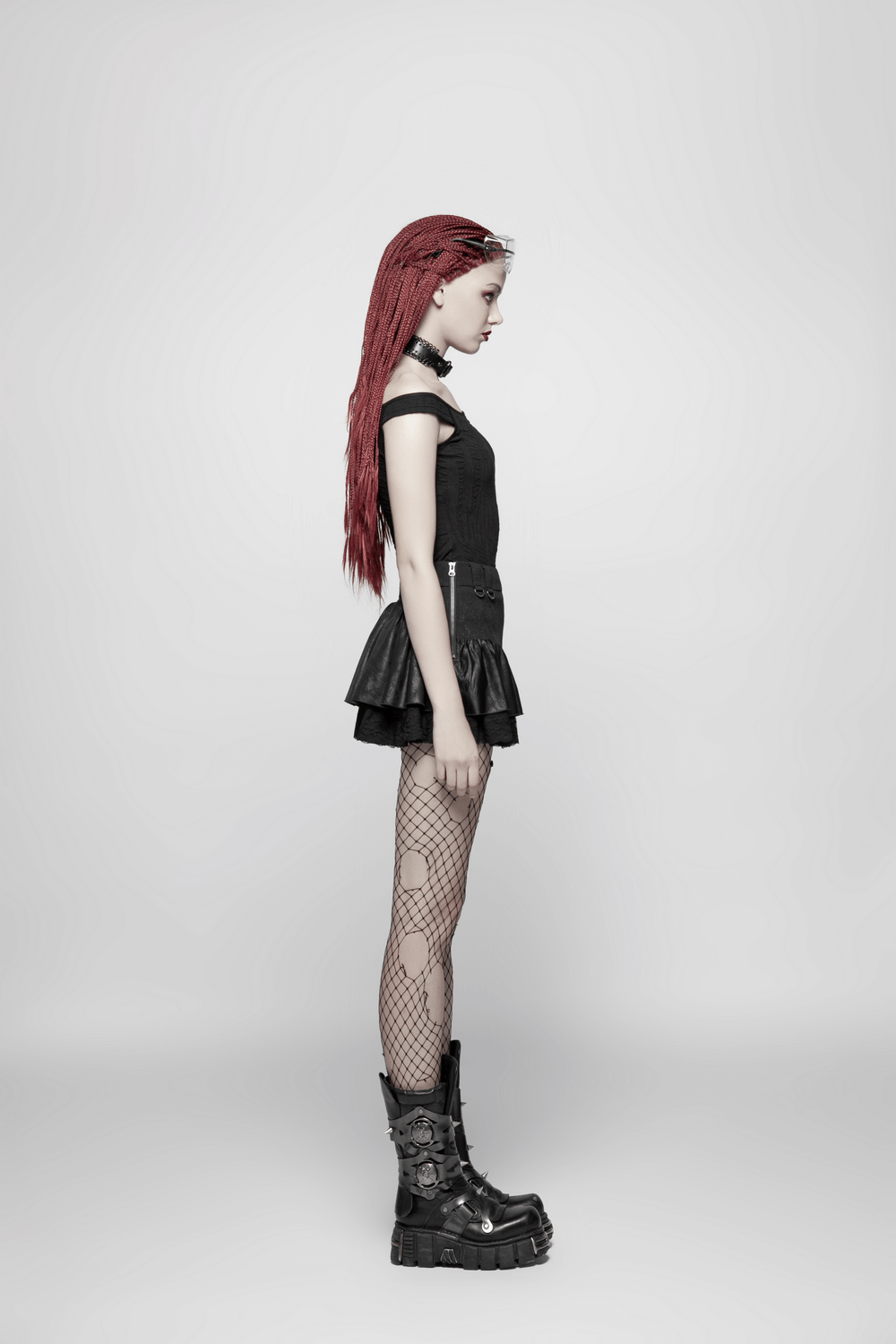Stylish punk rave mini skirt with ruffles and lace, paired with fishnet tights and chunky boots, showcasing edgy fashion.