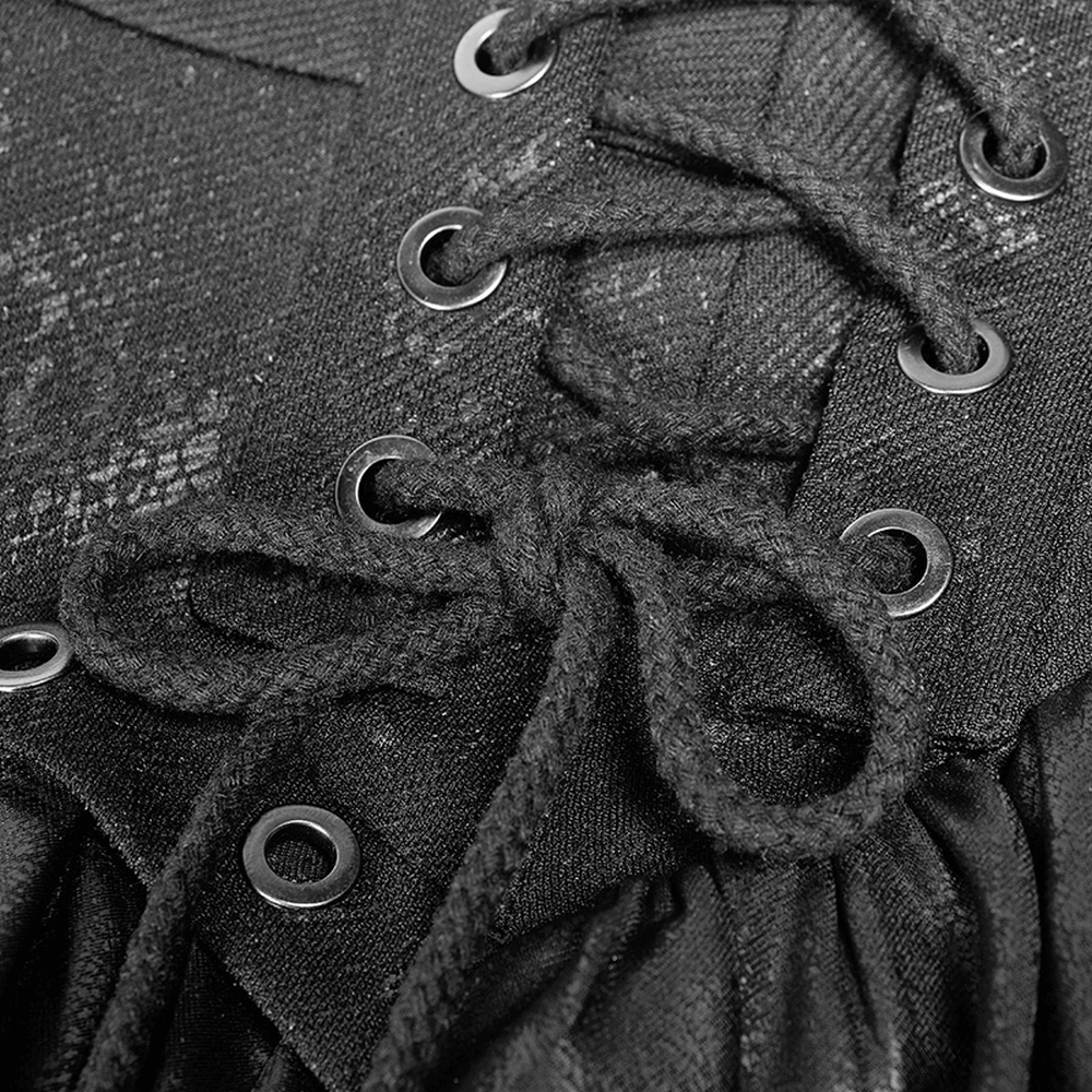 Close-up of black punk mini skirt featuring lace-up detail with metal eyelets and ruffled texture.