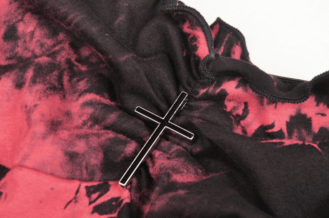 Close-up of a stylish punk rock dress with red and black tie-dye fabric and silver cross embellishment.