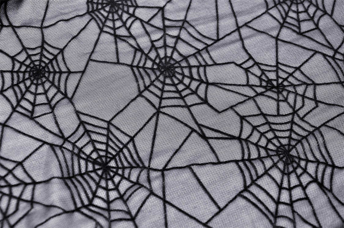 Close-up of black spiderweb mesh design on a gothic sleeveless t-shirt, perfect for a punk edge in fashion.