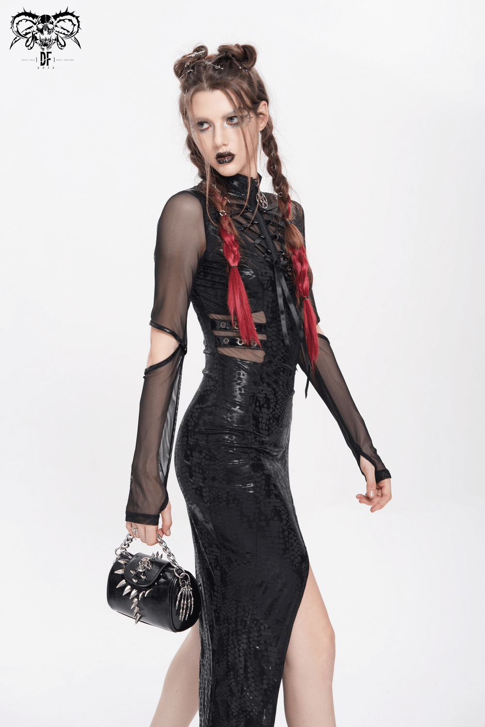 Model in a black sequin dress with sheer sleeves, holding a studded handbag and showcasing edgy style.