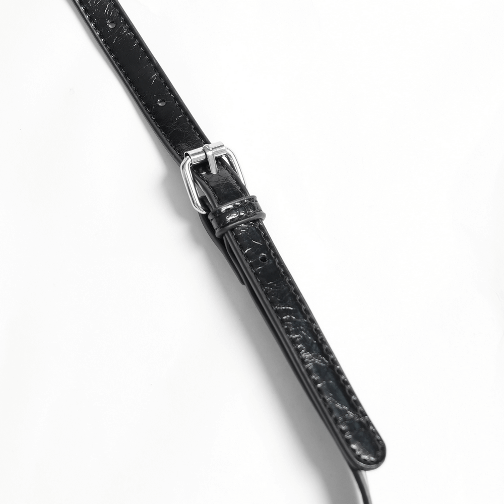 Close-up of a black leather shoulder bag strap with a sleek silver buckle and detailed texture.