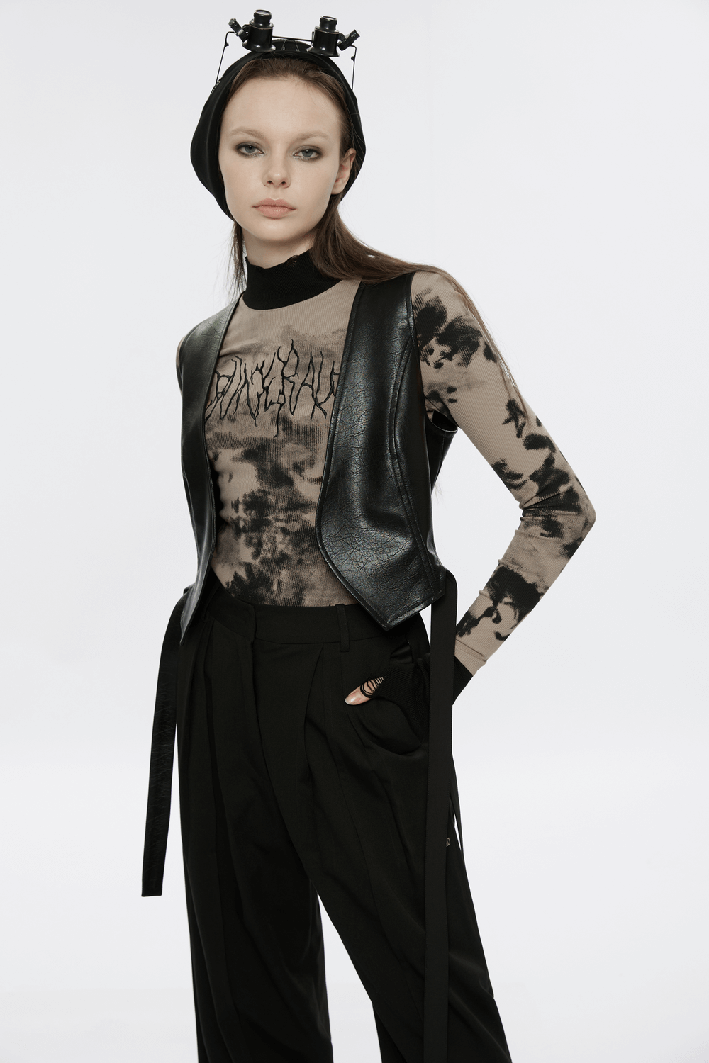 Edgy model wearing a stylish tie dye turtleneck top and a sleek leather vest, showcasing punk-inspired streetwear.