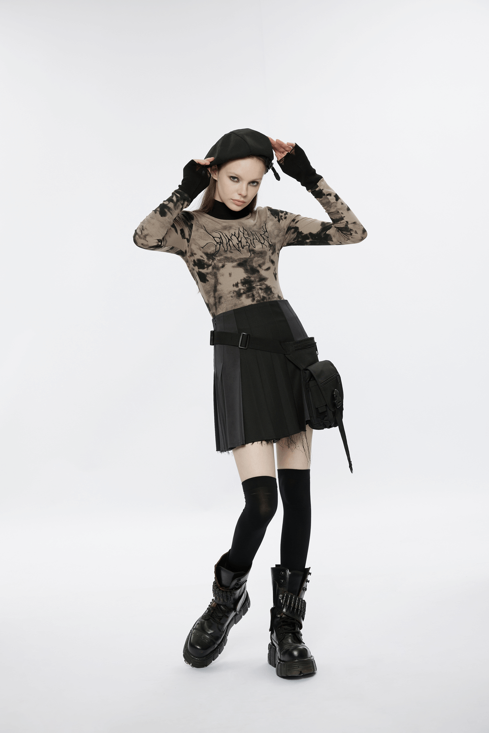 Model in a stylish tie dye turtleneck with ripped cuffs and a black skirt, showcasing edgy streetwear vibes.