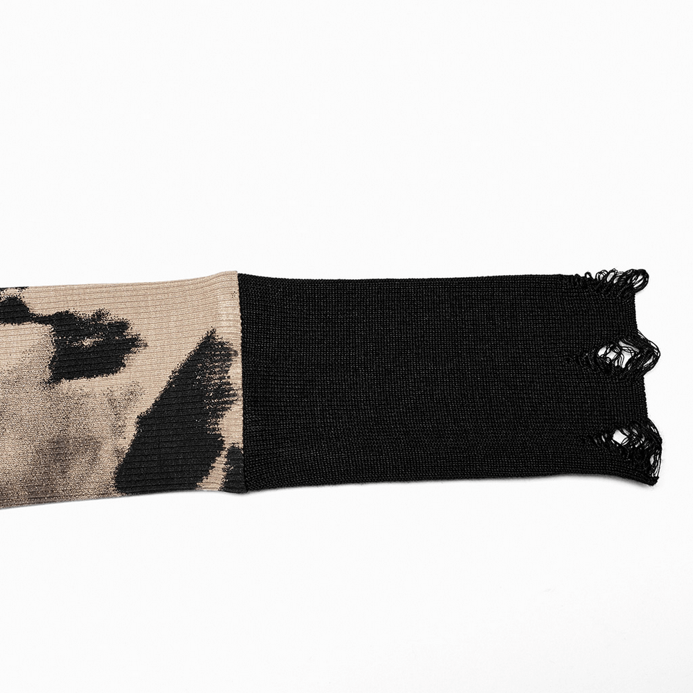 Close-up of stylish tie dye sweater sleeve with ripped cuffs, featuring a mix of black and beige patterns.