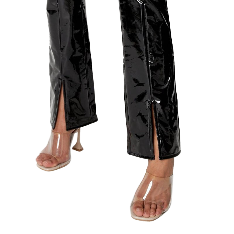 Close-up of stylish women's black patent leather straight pants with slits, paired with transparent heels.